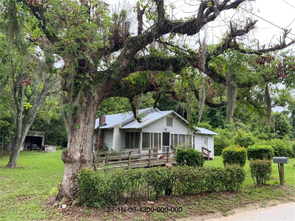 view of front facade with a front yard and a deck