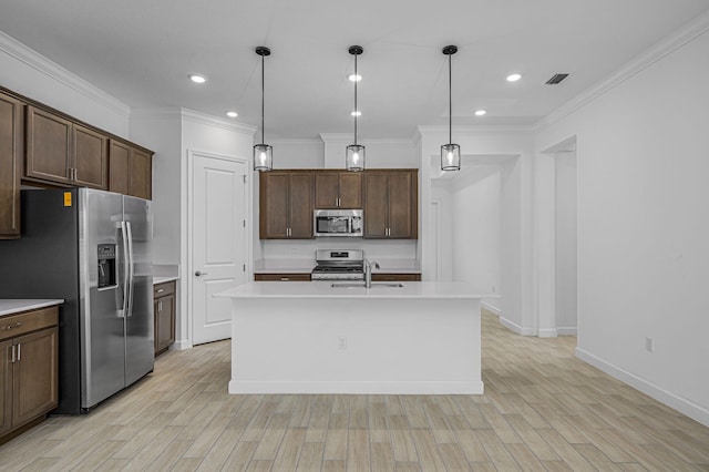 kitchen featuring hanging light fixtures, an island with sink, dark brown cabinets, light hardwood / wood-style floors, and stainless steel appliances