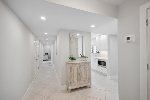 corridor with sink and light tile patterned flooring