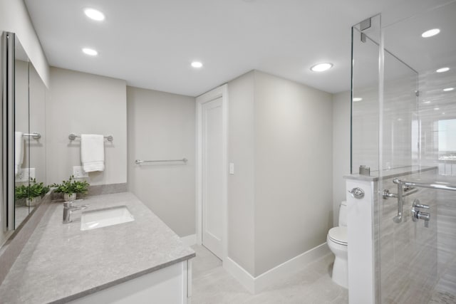 bathroom with vanity, toilet, and a shower with door