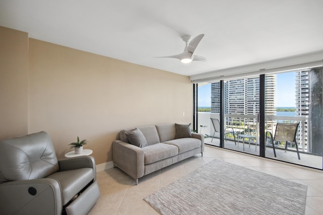 living room with a water view, ceiling fan, and light tile patterned flooring