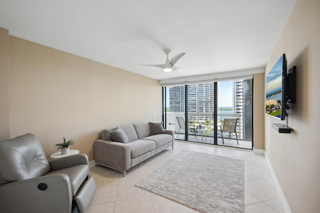 tiled living room with floor to ceiling windows and ceiling fan