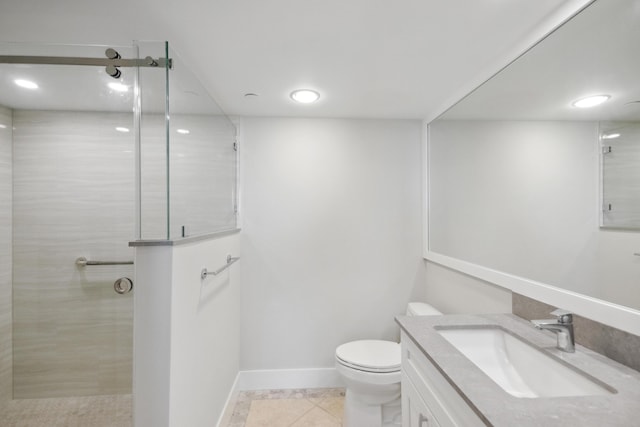 bathroom featuring a tile shower, vanity, toilet, and tile patterned floors