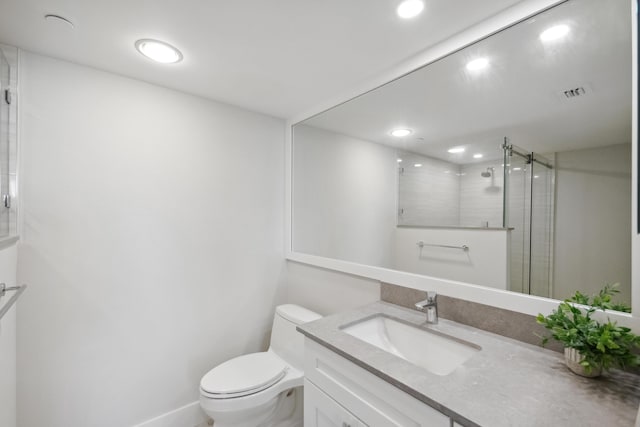 bathroom featuring toilet, vanity, and walk in shower