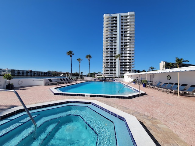 view of pool with a patio and a hot tub