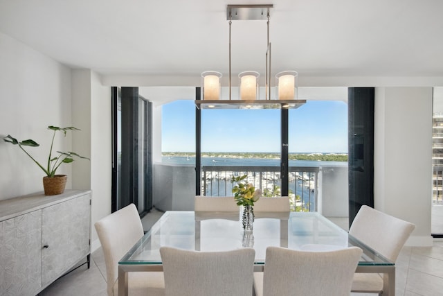 tiled dining room featuring a water view and a notable chandelier