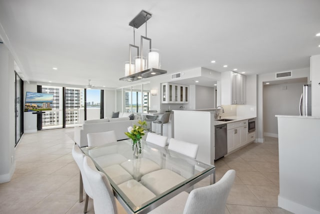 dining room featuring light tile patterned floors, ceiling fan, and sink