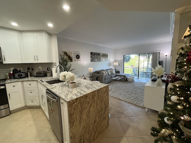 kitchen with backsplash, sink, light stone countertops, white cabinetry, and stainless steel appliances