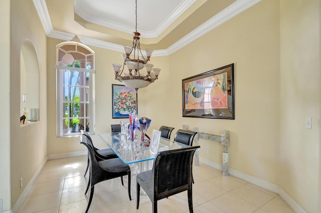 tiled dining space featuring a raised ceiling, ornamental molding, and a notable chandelier