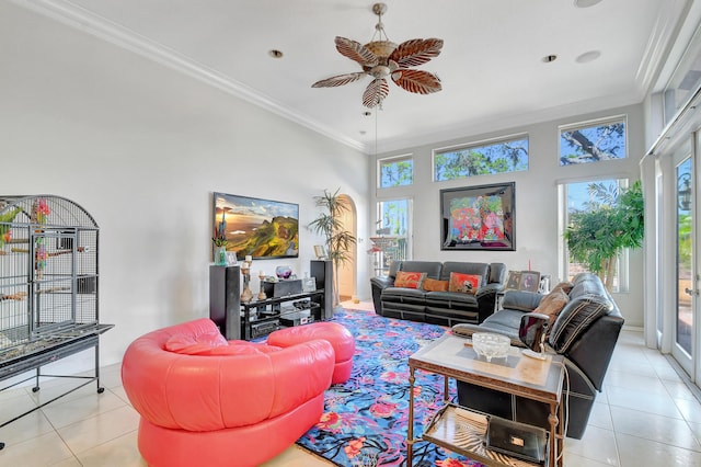 tiled living room featuring ceiling fan, a towering ceiling, and ornamental molding