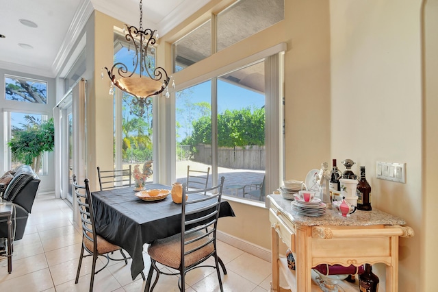 tiled dining space featuring a notable chandelier and ornamental molding