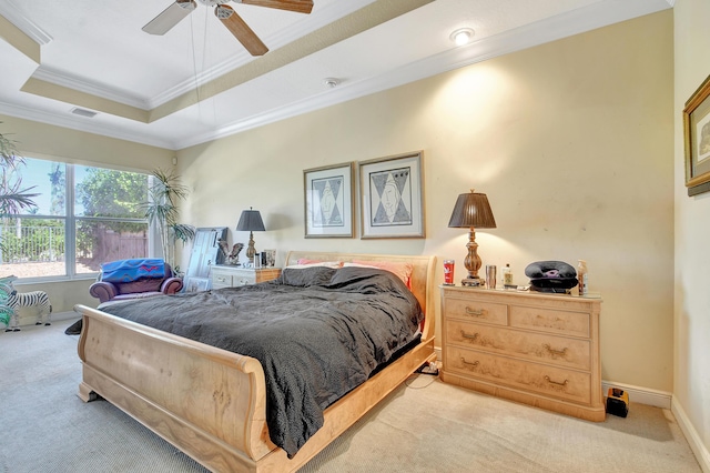 bedroom with a tray ceiling, ceiling fan, crown molding, and light colored carpet