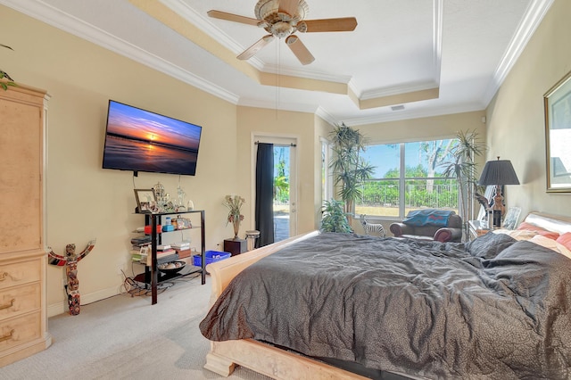 carpeted bedroom with ceiling fan, crown molding, and a tray ceiling