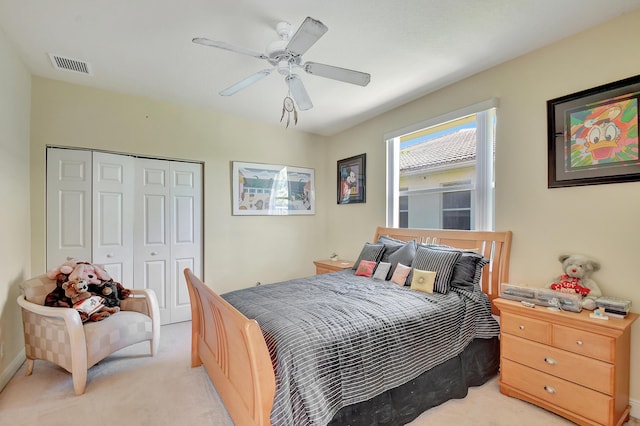 carpeted bedroom with ceiling fan and a closet