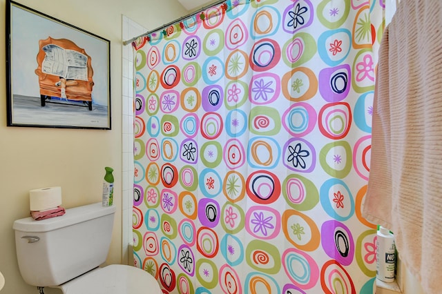 bathroom featuring a shower with shower curtain and toilet