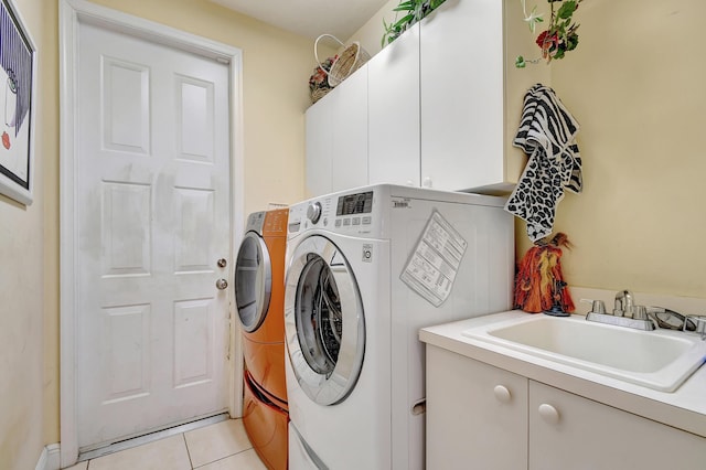 laundry room with sink, light tile patterned floors, cabinets, and independent washer and dryer