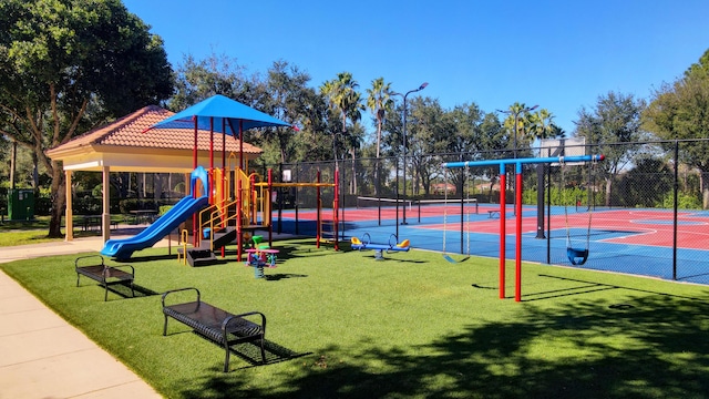 view of jungle gym featuring tennis court