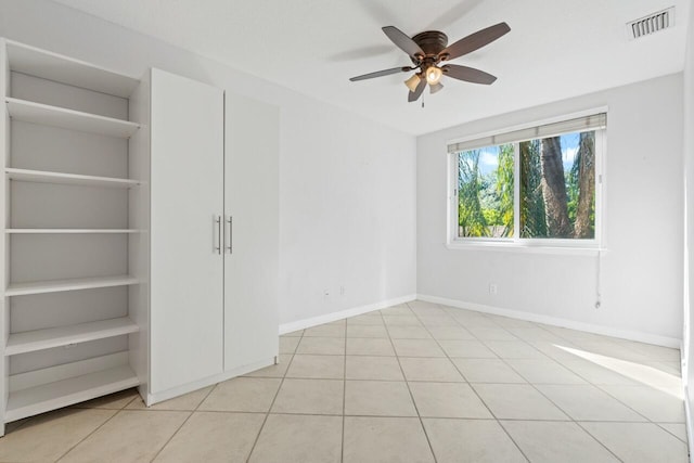 empty room with ceiling fan and light tile patterned flooring