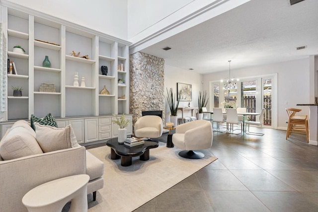 tiled living room with a chandelier, a textured ceiling, and a fireplace