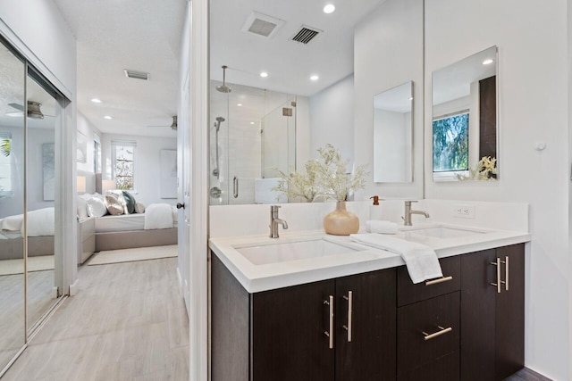 bathroom with an enclosed shower, vanity, and ceiling fan