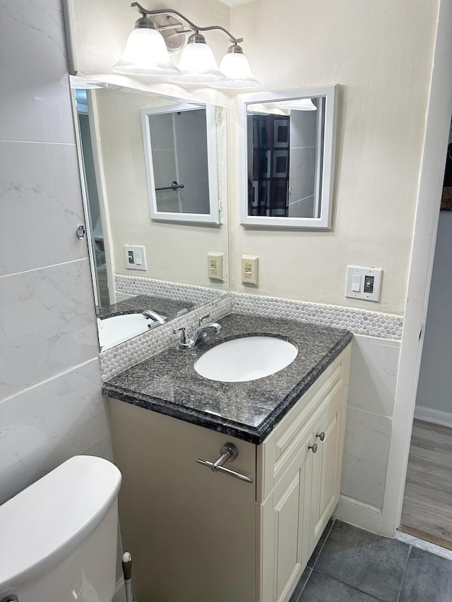 bathroom with tile patterned flooring, vanity, and toilet