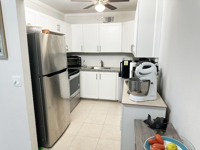 kitchen featuring white cabinets, sink, ceiling fan, light tile patterned floors, and appliances with stainless steel finishes