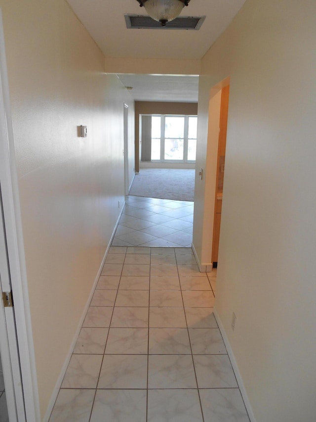 hall featuring light tile patterned floors