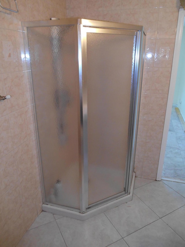 bathroom with tile patterned flooring and walk in shower