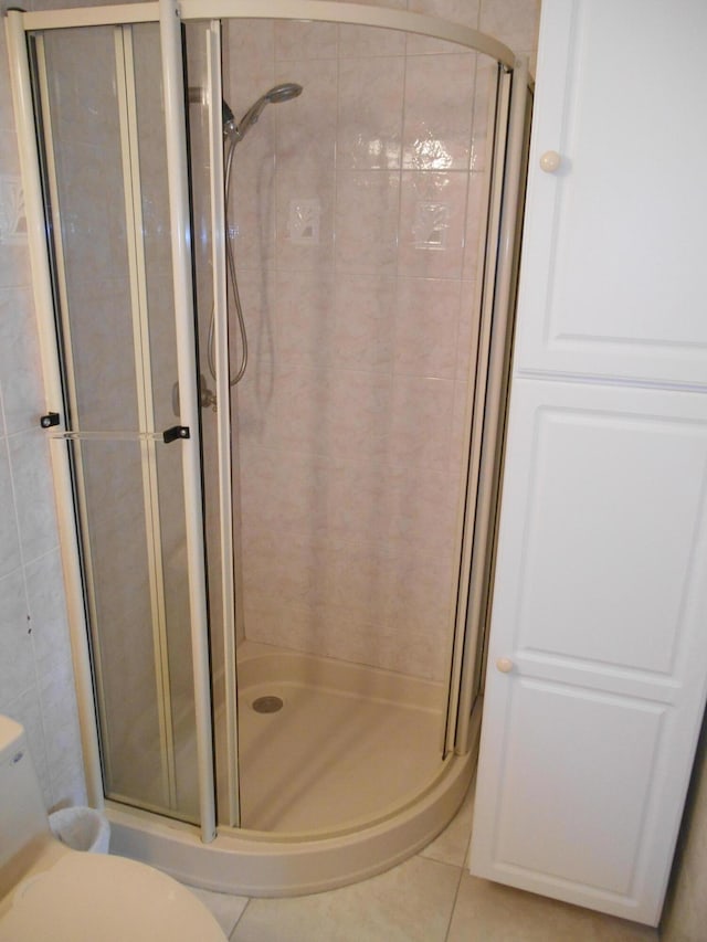 bathroom featuring tile patterned flooring and a shower with shower door