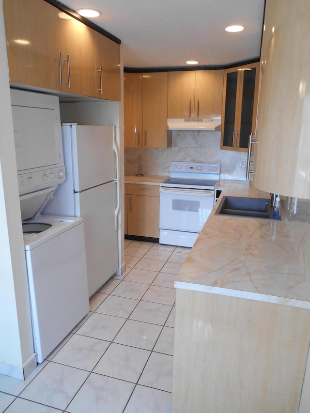 kitchen with tasteful backsplash, white appliances, sink, stacked washer / drying machine, and light tile patterned flooring