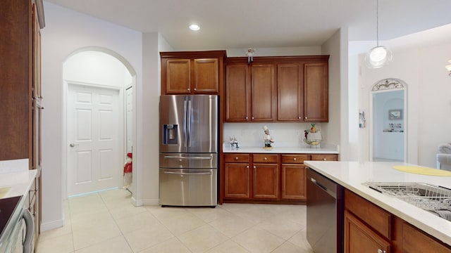 kitchen with light tile patterned floors, hanging light fixtures, and appliances with stainless steel finishes