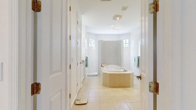 bathroom featuring tile patterned floors and tiled tub