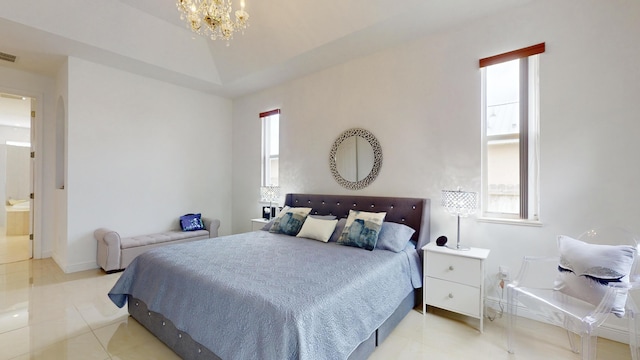 bedroom featuring light tile patterned floors, ensuite bathroom, an inviting chandelier, and a tray ceiling