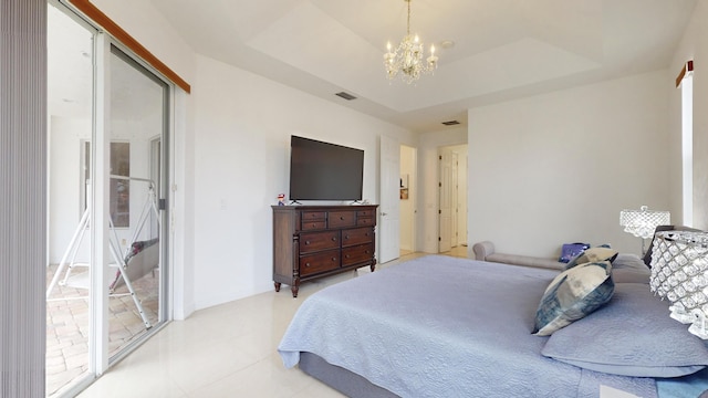 bedroom featuring a chandelier, a raised ceiling, and multiple windows