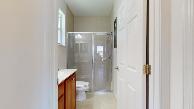 bathroom with tile patterned flooring, vanity, an enclosed shower, and toilet