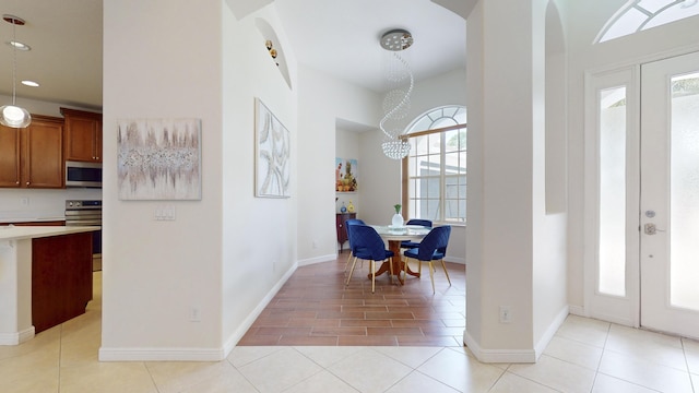 entrance foyer with plenty of natural light, light tile patterned floors, and a chandelier