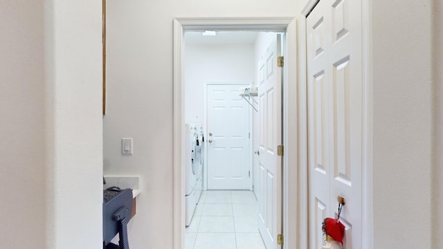 hall with washer and clothes dryer and light tile patterned floors