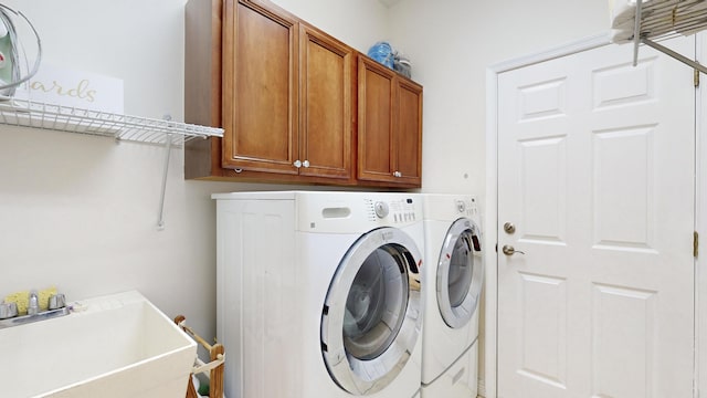 laundry area with cabinets, separate washer and dryer, and sink