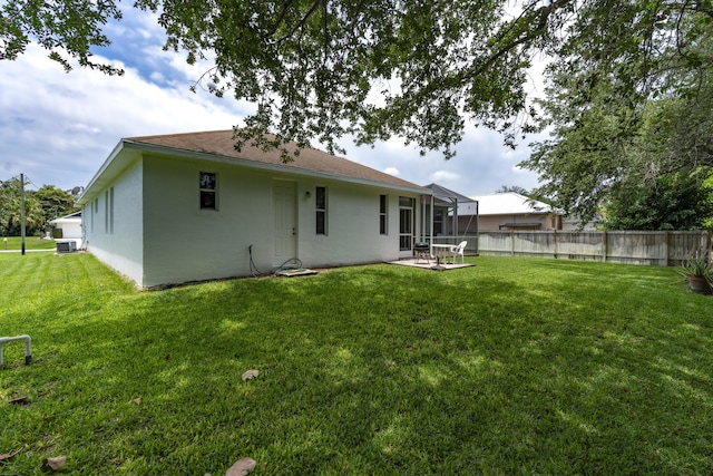 back of house with a yard, central AC, and a patio area