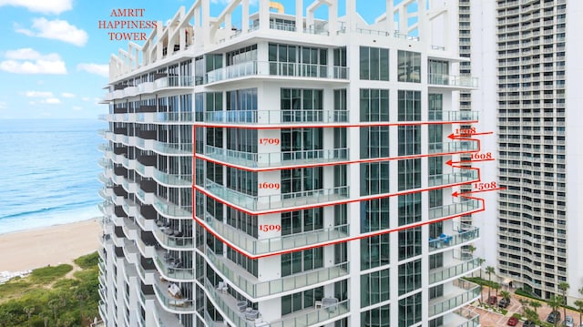 view of building exterior with a water view and a view of the beach