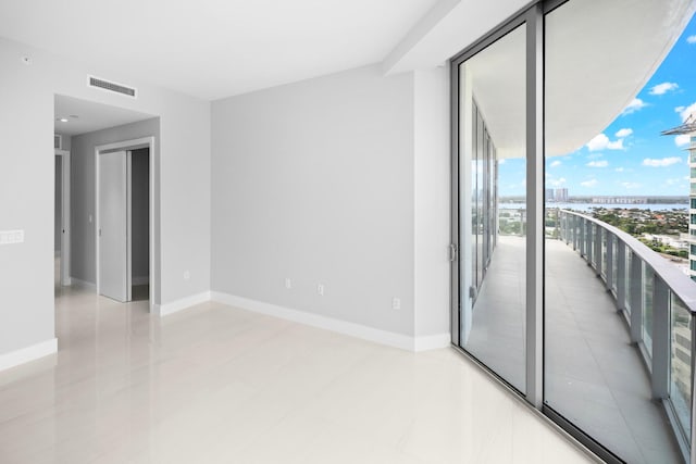 tiled spare room with a wall of windows