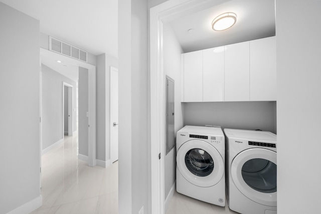 clothes washing area featuring washer and clothes dryer and cabinets