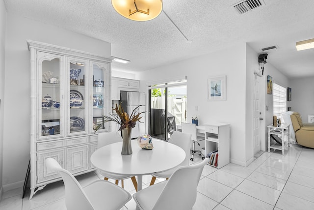 dining room featuring light tile patterned floors and a textured ceiling