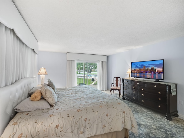 bedroom featuring access to outside, carpet, and a textured ceiling