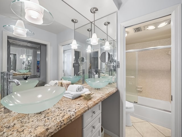 full bathroom featuring tile patterned flooring, vanity, toilet, and shower / bath combination with glass door