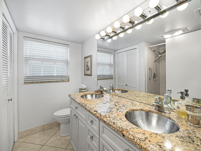 bathroom featuring tile patterned floors, vanity, toilet, and tiled shower