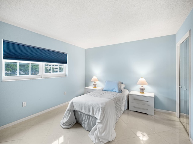 tiled bedroom with a textured ceiling