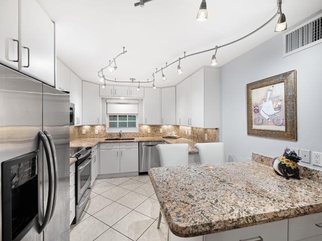 kitchen featuring kitchen peninsula, white cabinets, and appliances with stainless steel finishes