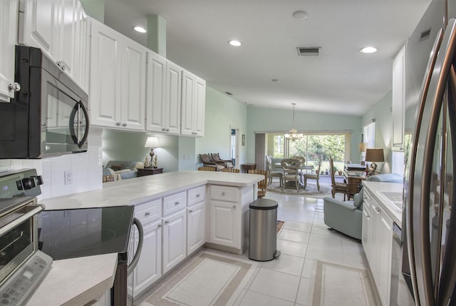 kitchen with lofted ceiling, decorative light fixtures, white cabinetry, kitchen peninsula, and stainless steel appliances