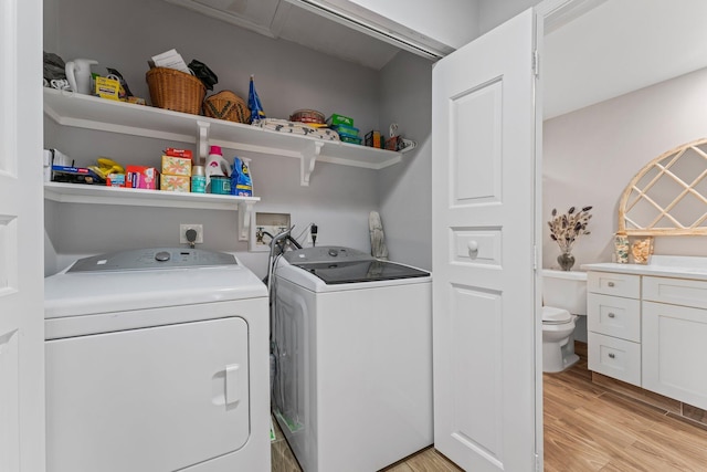 washroom featuring washing machine and dryer and light hardwood / wood-style floors